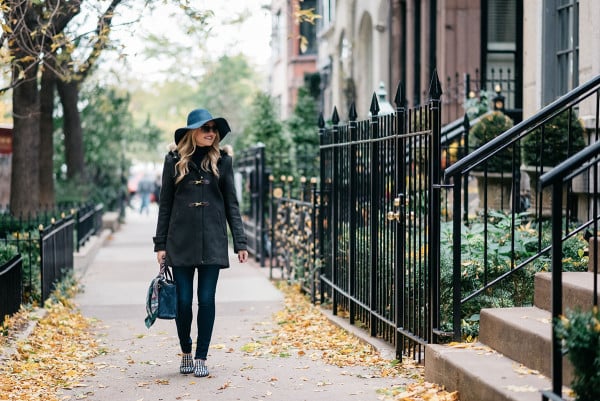Bows & Sequins styling a fall outfit: floppy hat, dark green toggle coat, Rag & Bone skinny jeans, Gucci loafers, Tom Ford sunglasses, and a Kate Spade bag.