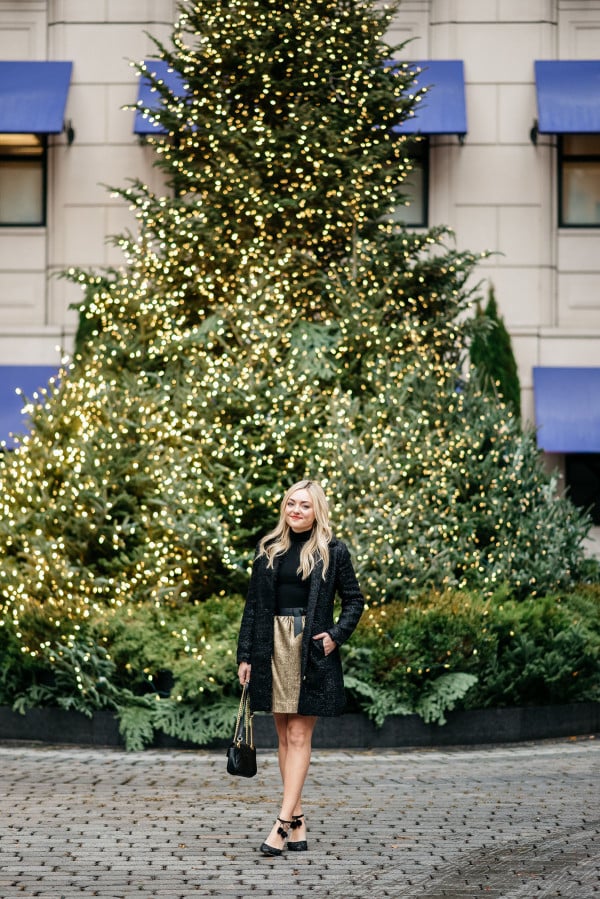 Bows & Sequins styling a black and gold holiday outfit: Sail to Sable sparkly tweed jacket, a black turtleneck, a gold tweed skirt with a bow belt, a Gucci Marmont bag, and Kate Spade glitter pom-pom heels! Photo taken in front of the Christmas Tree at the Waldorf Astoria in Chicago's Gold Coast.