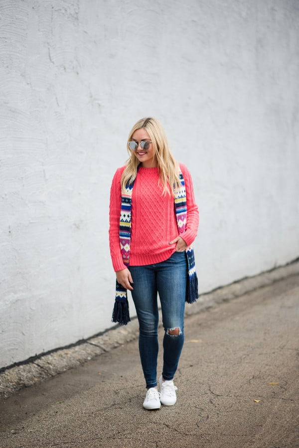 Bows & Sequins wearing a neon pink sweater with a fair isle scarf and white sneakers