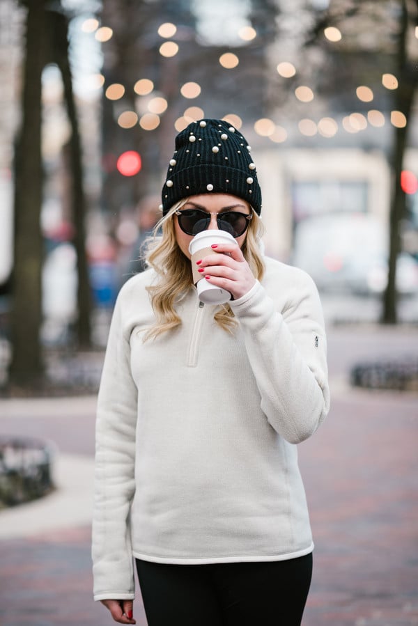 Bows and Sequins wearing a pearl beanie, Karen Walker sunglasses, and a Patagonia pullover.