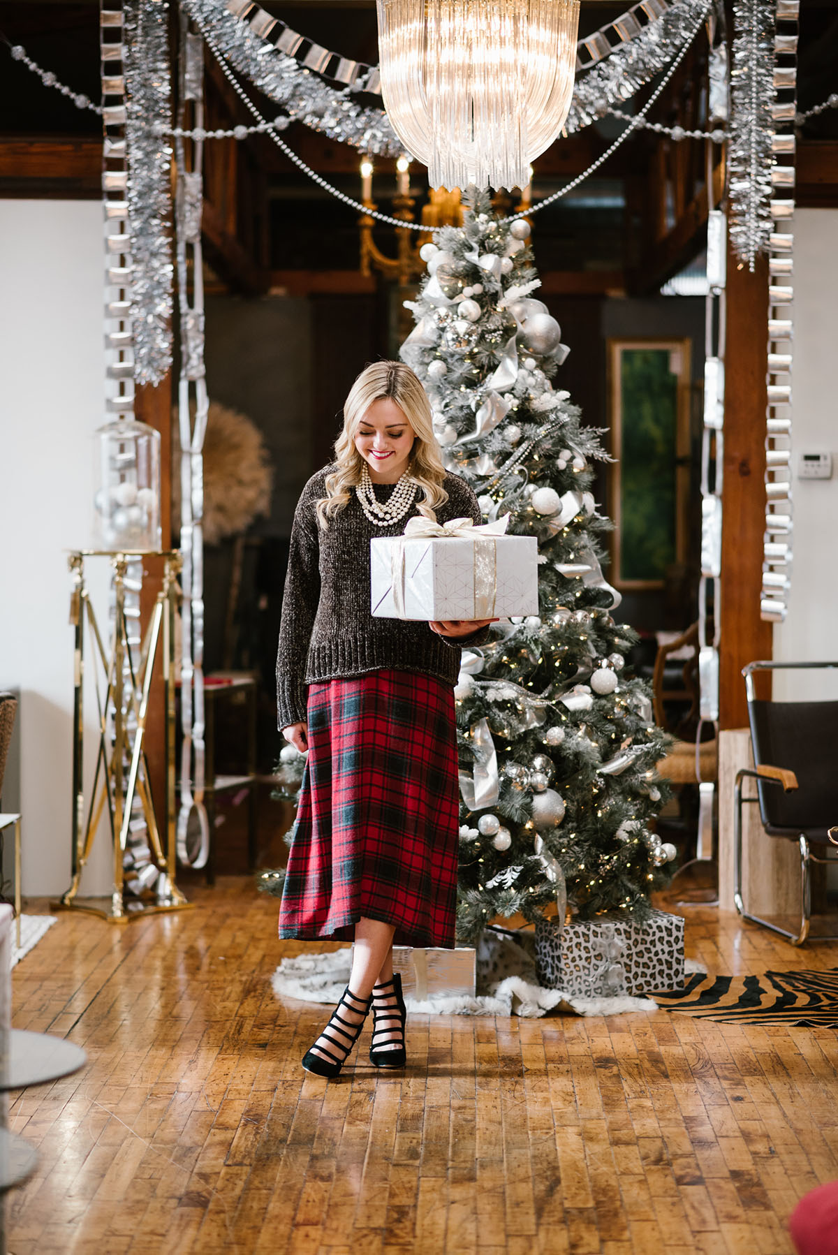 Bows & Sequins styling an outfit perfect for a casual holiday party or Christmas with family! Green chenille sweater layered over a plaid dress with heels and pearls!