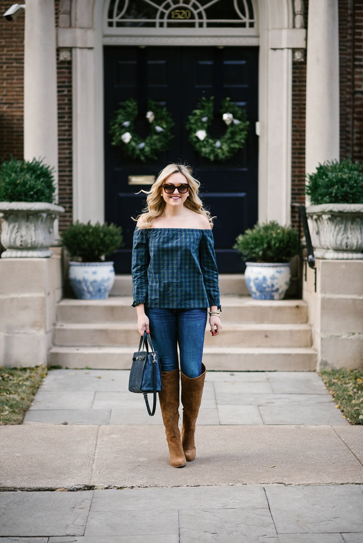 Bows & Sequins wearing a Vineyard Vines blackwatch plaid off-the-shoulder shirt, Rag & Bone skinny jeans, and tan suede over-the-knee boots.