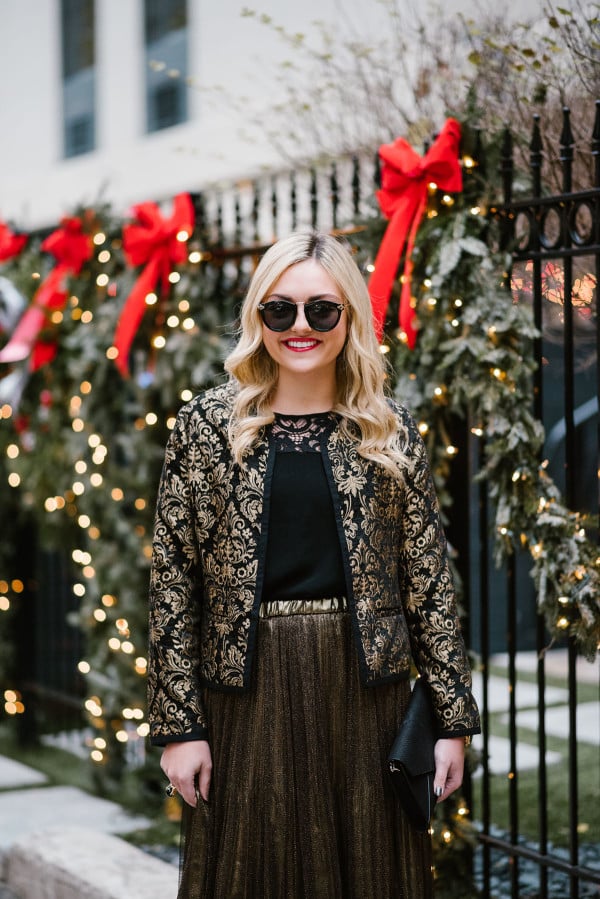 Bows & Sequins wearing a black & gold jacket, black lace top, and gold skirt for a holiday party outfit.