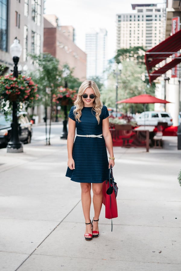 Bows & Sequins styling a navy Sail to Savle dress with a Tommy Hilfiger x Gigi Hadid red tote.