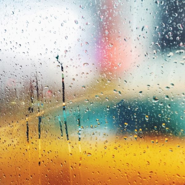 The view from a rainy New York City cab window with a yellow taxi.