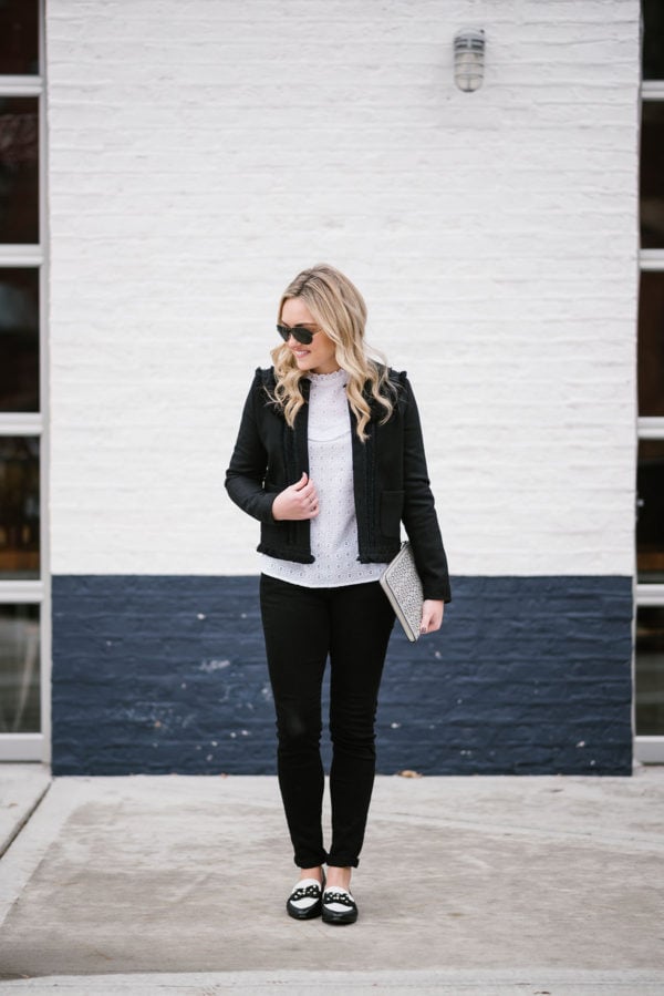 Bows & Sequins styling a black jacket and white lace top from Sezane with black jeans and bow loafers.
