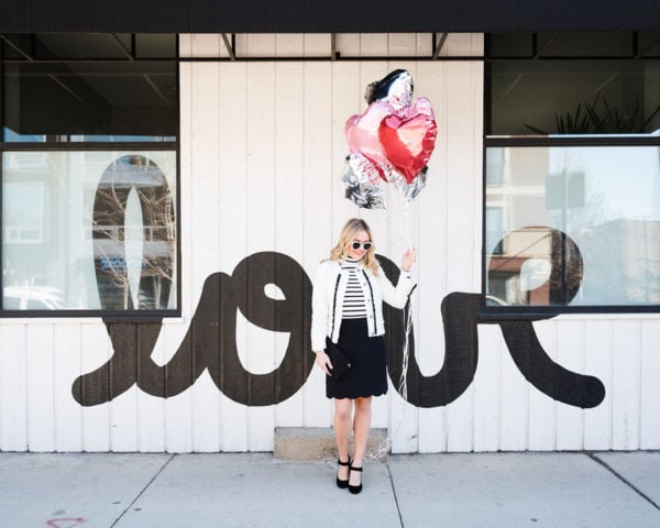 Bows & Sequins styling a black and white outfit for Valentine's Day in front of a LOVE wall in Chicago.
