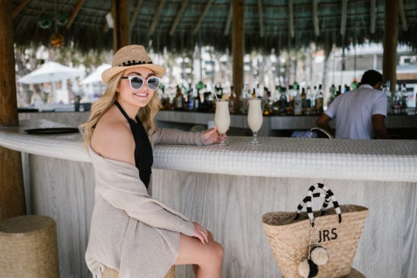 Bows & Sequins wearing a Vineyard Vines tassel cardigan by the pool bar at Paradisus Los Cabos in Cabo Mexico.