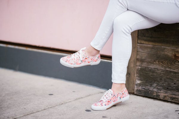 Bows & Sequins wearing white jeans and printed sneakers.