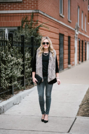 Bows & Sequins wearing a faux fur vest and grey skinny jeans.