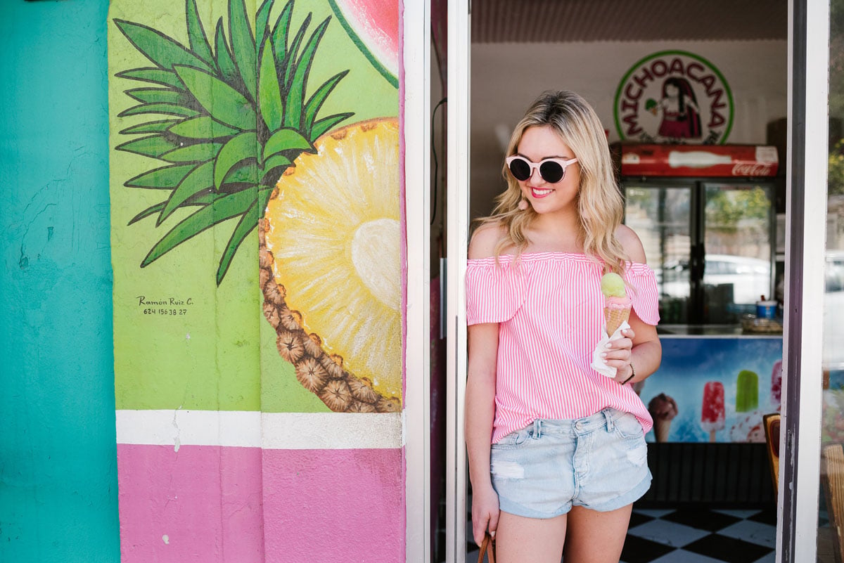 Lifestyle blogger Bows & Sequins wearing a Vineyard Vines blouse and Amuse Society cut off jean shorts.
