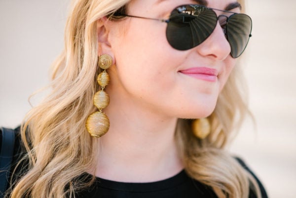 Fashion blogger Bows & Sequins wearing gold Tuckernuck earrings and Ray-Ban black aviators.