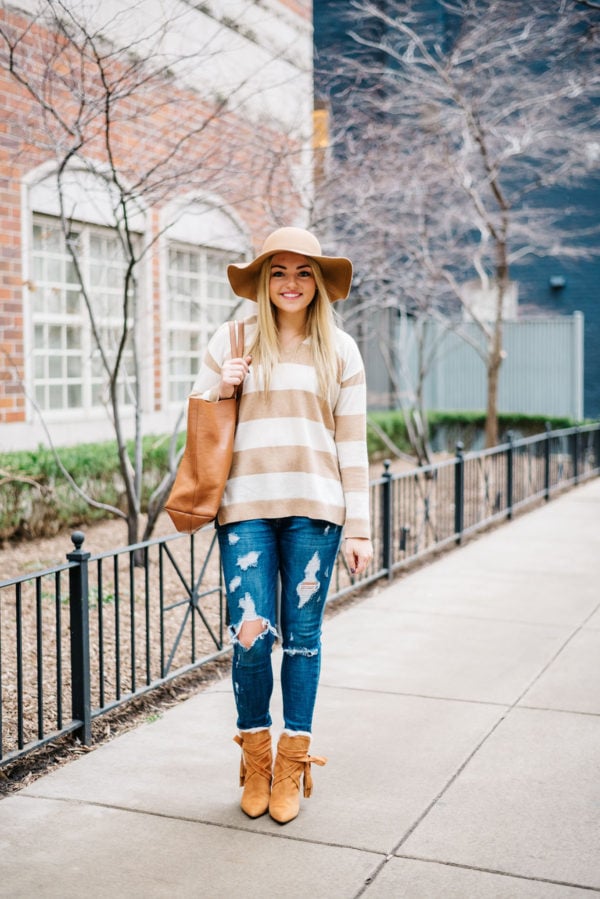 Bows & Sequins wearing a camel striped sweater with ripped jeans.