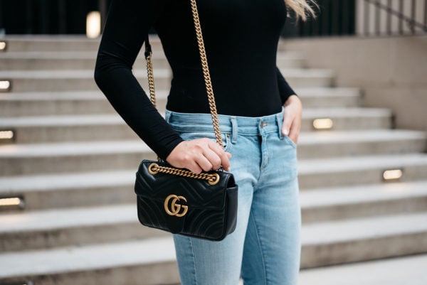 Chicago blogger Jessica Sturdy pairing a black bodysuit, light wash jeans, and a Gucci Marmont shoulder bag.