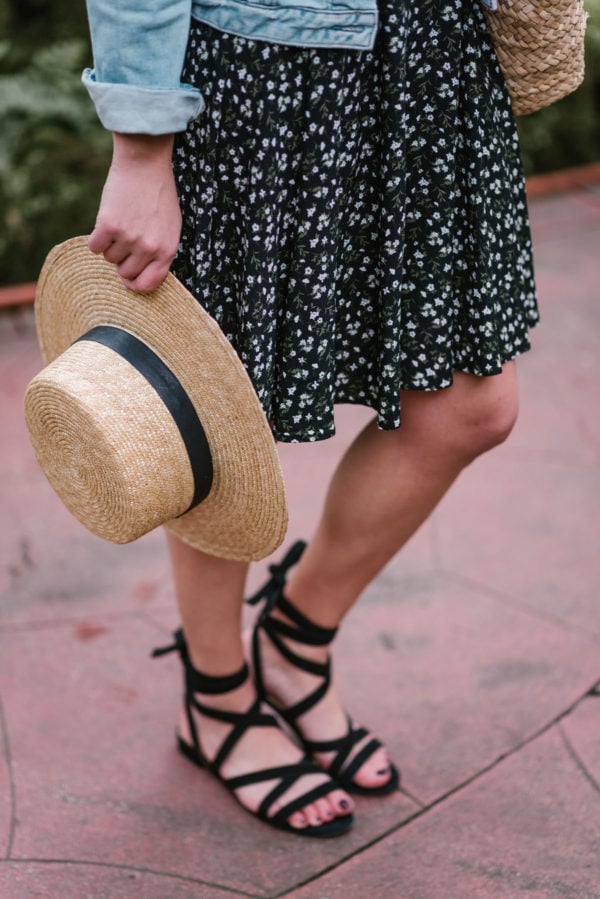 Bows & Sequins accessorizing a floral printed Old Navy dress with a straw hat and black lace up M. Gemi sandals.