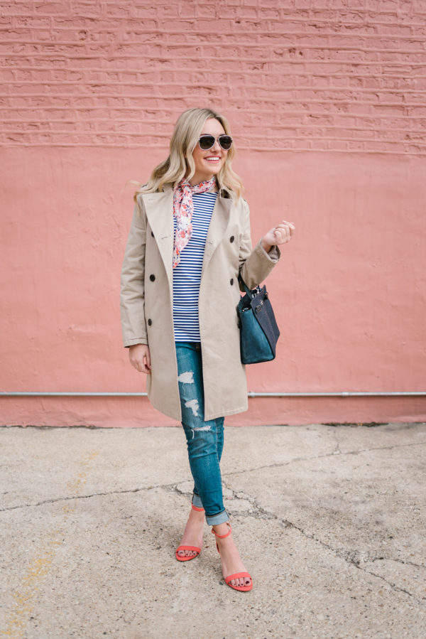 Bows & Sequins styling a women's trench coat with a navy Kate Spade bag and distressed skinny jeans.