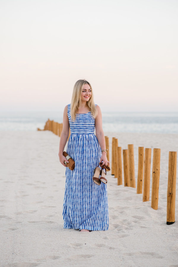 Lifestyle blogger Bows & Sequins wearing a navy striped maxi dress on the beach in Cabo San Lucas, Mexico at the Paradisus Hotel.
