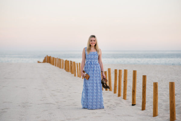 Bows & Sequins wearing a Vineyard Vines blue striped maxi dress on the beach at sunset in Cabo San Lucas, Mexico.