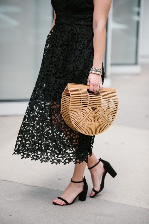Bows & Sequins wearing a black lace dress with a Cult Gaia bag.