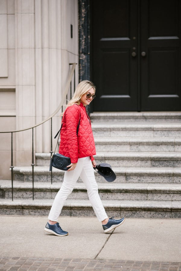 Bows & Sequins wearing a quilted jacket, white corduroys, a navy blue Gucci bag, and blue leather sneakers.