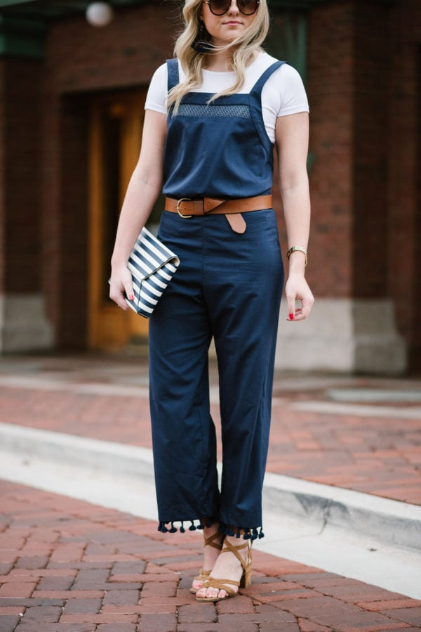 Bows & Sequins styling a navy blue jumpsuit with a white tee underneath.