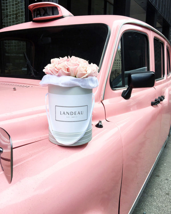 Bows & Sequins Instagram photo of Landeau blush pink roses in a shoe box in front of the pink taxi at the Langham luxury hotel in Chicago