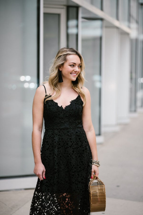 Bows & Sequins styling a black lace dress with long tassel earrings.