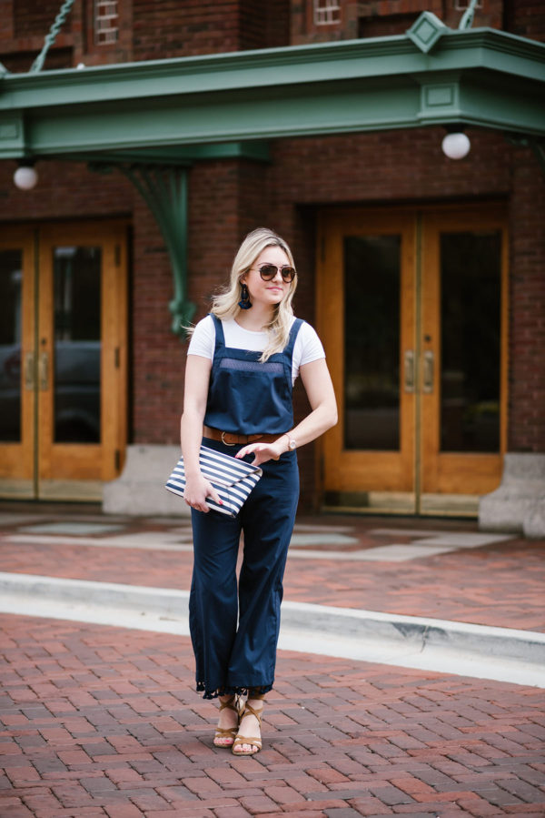 Bows & Sequins wearing a navy blue jumpsuit with a white tee underneath in front of North Pond at Lincoln Park in Chicago.