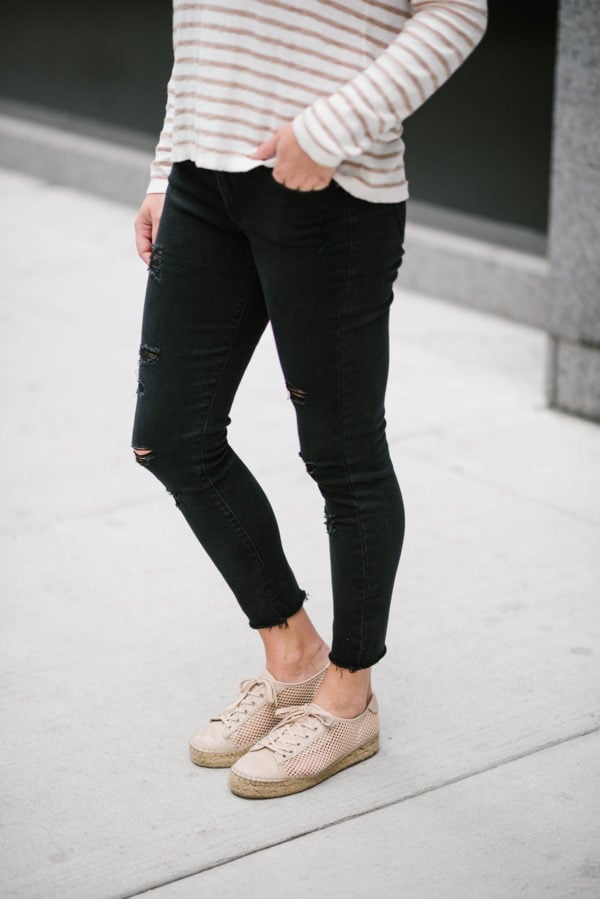 Travel writer Bows & Sequins wearing black raw hem jeans from Old Navy with a Kenzie striped sweater and Marc Fisher espadrille sneakers.