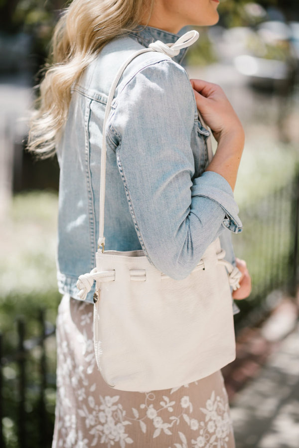 Fashion blogger Bows & Sequins styling a white Clare V Petit Henri bag for a music festival.
