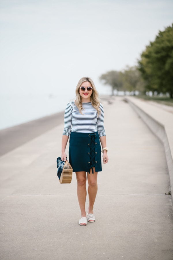 Chicago lifestyle blogger Bows & Sequins wearing Call It Spring sunglasses, a Lands End navy striped tee, a lace-up skirt, and a bamboo handbag.