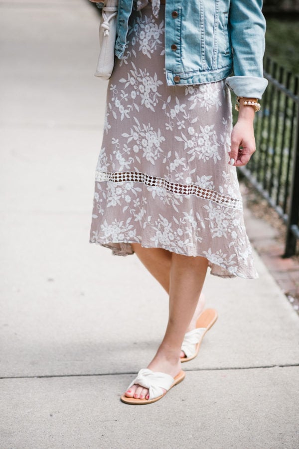 Fashion stylist Bows & Sequins wearing an ASTR tie-front floral midi dress and white Soludos knotted slides with a pearl cuff.