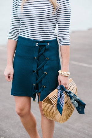 Jessica Sturdy of Bows & Sequins, a Chicago based fashion blog, wearing a Lands End striped tee and a navy skirt with a Cult Gaia bamboo bag, a navy bandana, and a Sweet & Spark pearl bracelet.