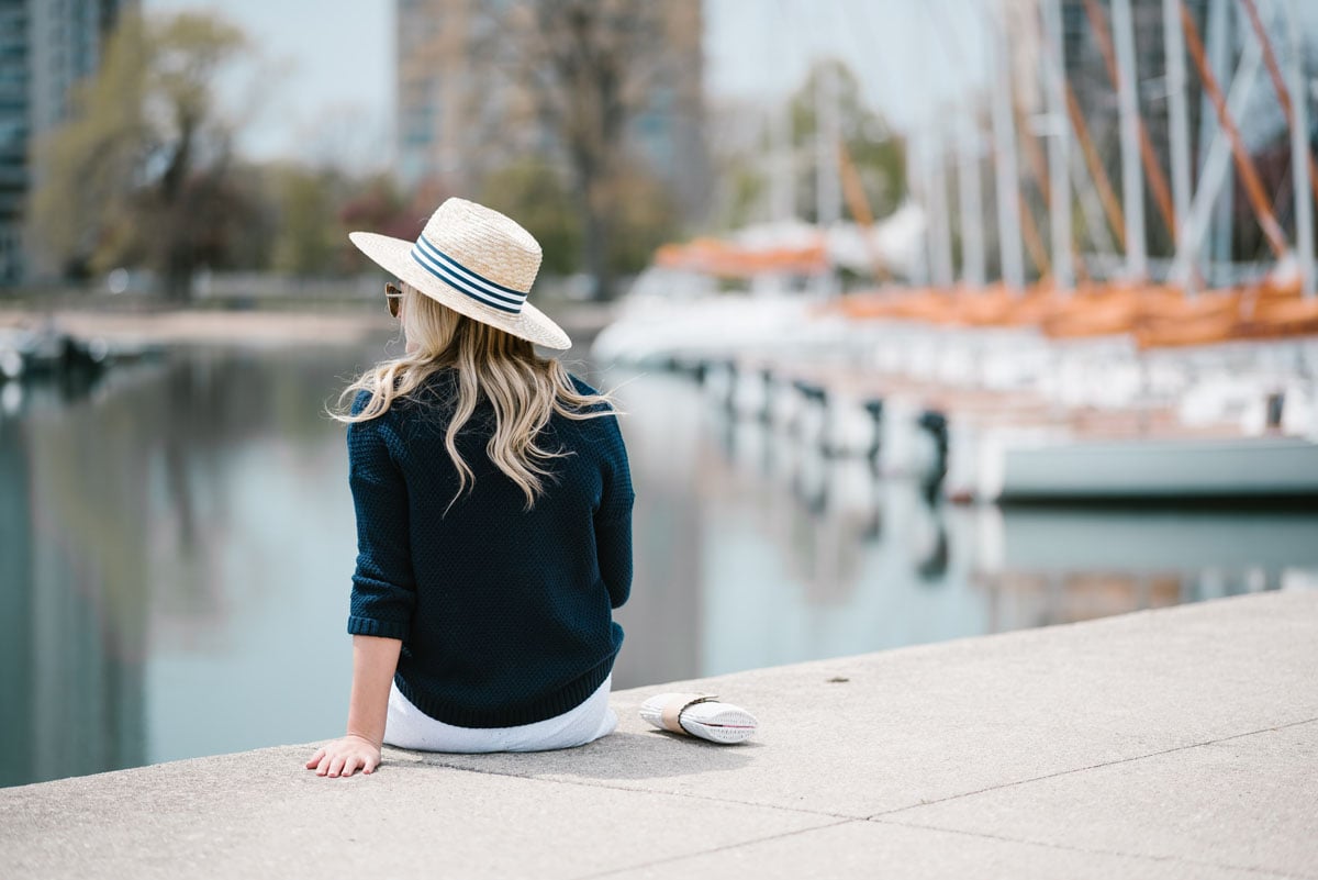 Chicago blogger Jessica Sturdy wearing a Hat Attack x Lemon Stripes straw hat and a navy sweater.