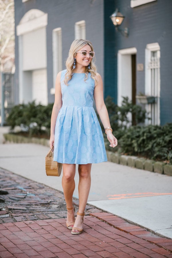 Bows & Sequins wearing a blue polka dot fit and flare dress with a Cult Gaia bamboo bag and leather espadrille wedge sandals.