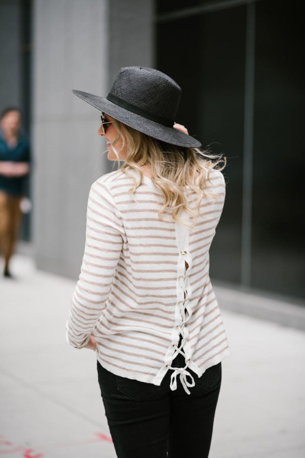 Travel writer Bows & Sequins wearing a Kenzie striped tie-back sweater with a black straw hat and Ray-Ban aviators.