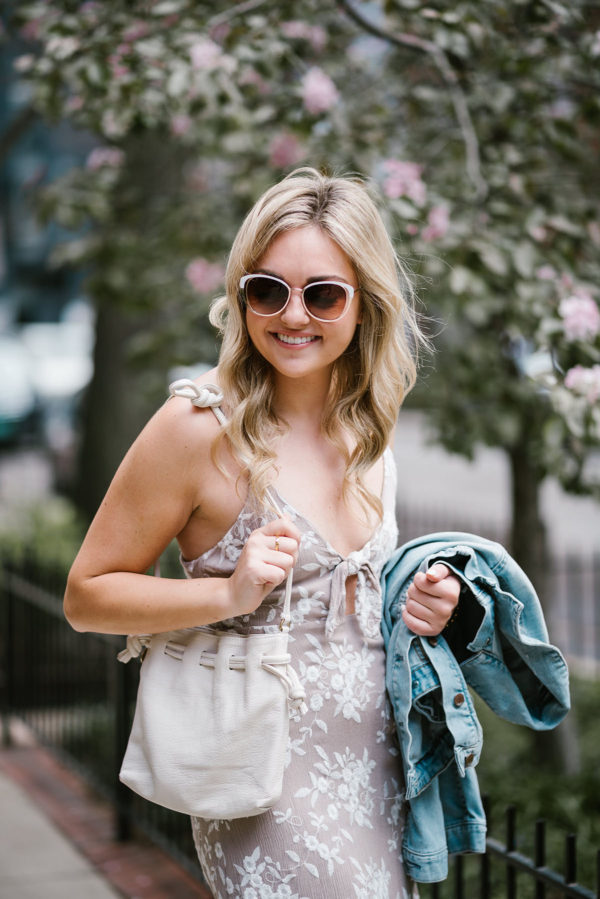 Lifestyle blogger Bows & Sequins wearing a floral tie-front dress, a Gap jean jacket, and Call It Spring sunglasses with a white Clare V Petit Henri bag.