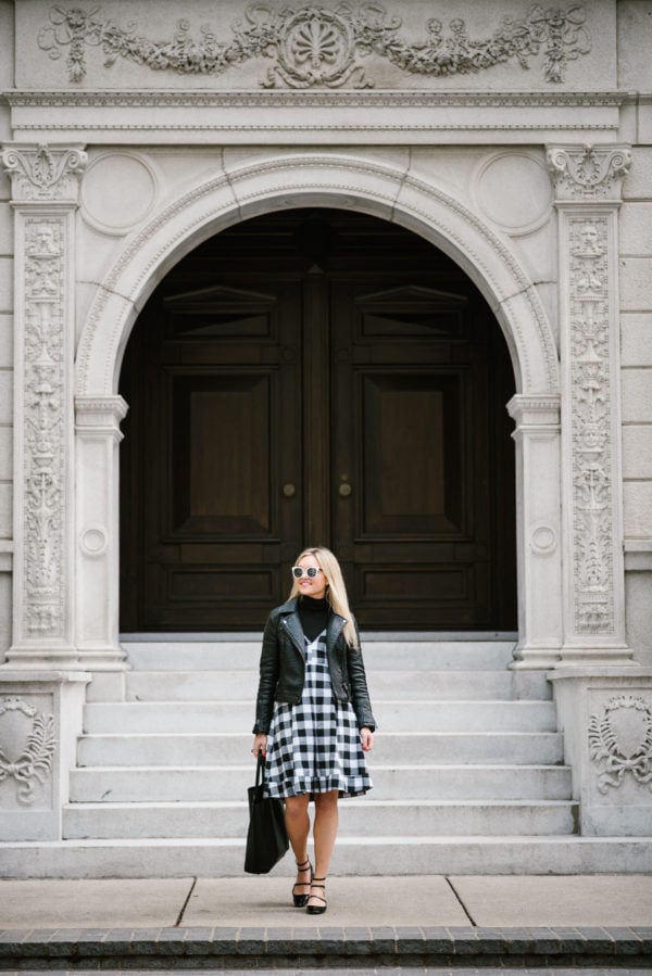Bows & Sequins wearing a Topshop moto jacket and black gingham Modcloth midi dress with a leather tote and strappy Mary Janes.