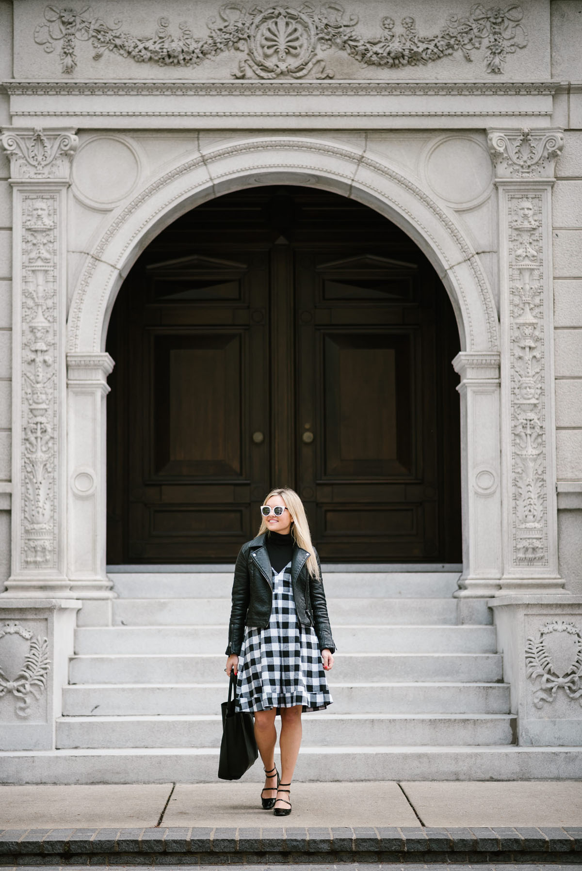 Bows & Sequins wearing a Topshop moto jacket and black gingham Modcloth midi dress with a leather tote and strappy Mary Janes.