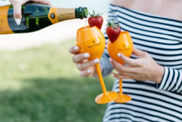 Bows & Sequins pouring champagne by Lake Michigan.