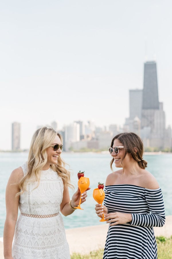 Chicago lifestyle bloggers Bows & Sequins and Hallie Wilson drinking Veuve Clicquot champagne by Lake Michigan.