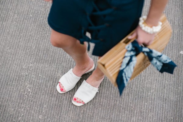 Chicago fashion blogger Bows & Sequins wearing white Kurt Geiger slides with a Cult Gaia bamboo bag, a navy bandana, and a pearl bracelet.