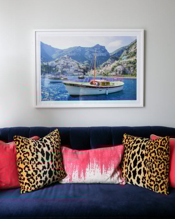 Bows & Sequins Chicago living room with navy velvet Society Social couch with pink and leopard throw pillows and a framed Gray Malin Italy print.