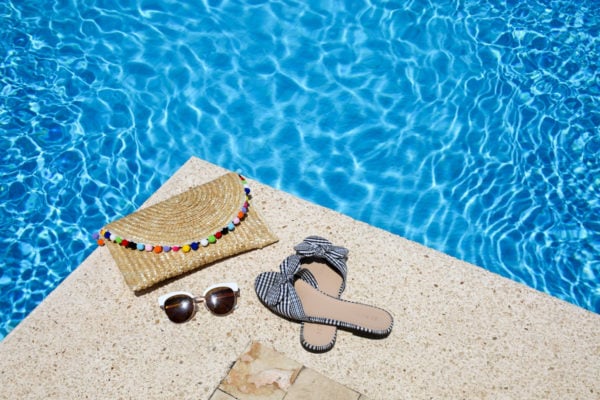 Bows & Sequins shares her pool must haves: an Alice & Wonder pom pom clutch, gingham bow slides, sunglasses