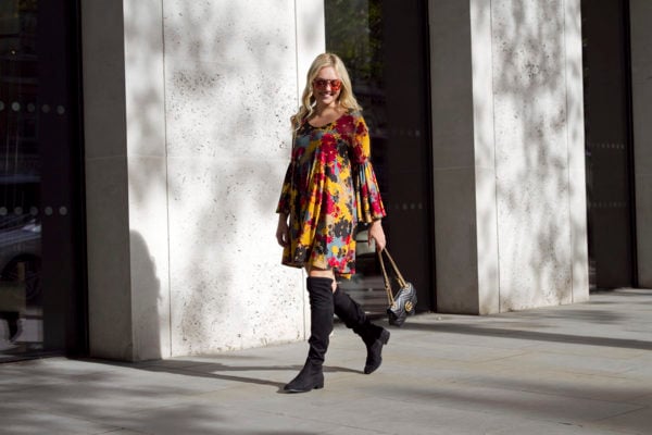 Travel blogger Bows & Sequins wearing a printed dress with over the knee boots and a Gucci Marmont bag in London.