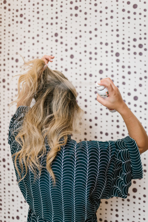Blonde using dry shampoo spray.