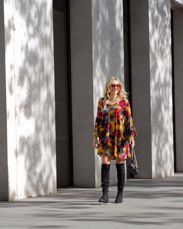 Bows & Sequins wearing a printed floral bell sleeve dress with black suede over the knee boots and a Gucci Marmont bag.