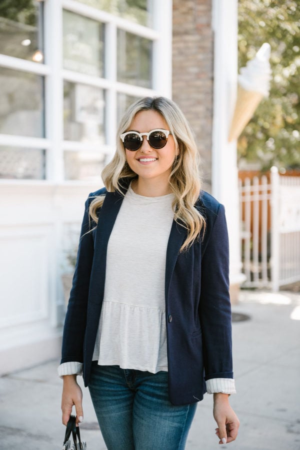 Jessica of Bows & Sequins, a Chicago based fashion-focused blog, wearing Illesteva sunglasses, a navy Express knit blazer, and an Old Navy peplum ruffle tee.