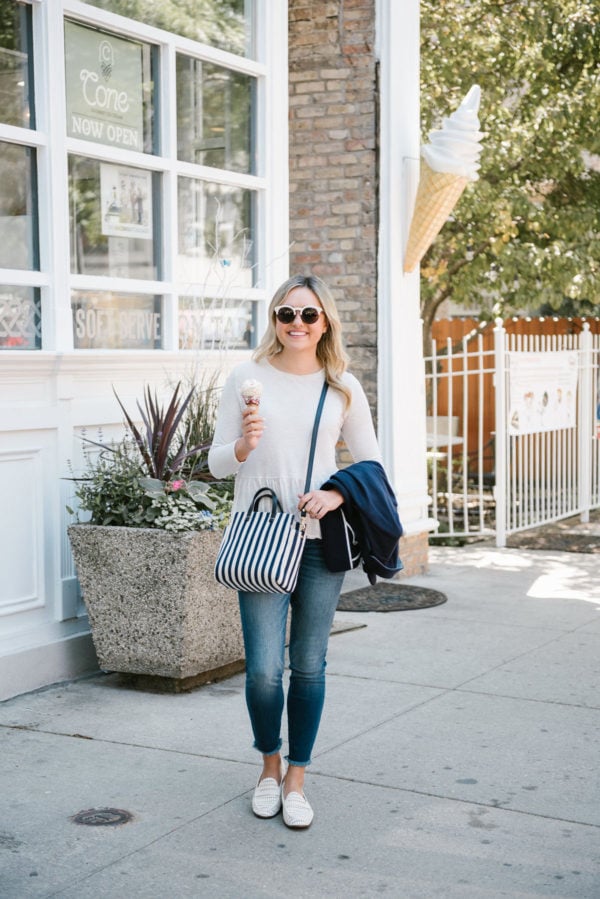 Bows & Sequins, a Chicago based lifestyle blogger, wearing Kut from the Cloth raw hem skinny jeans, an Old Navy ruffle peplum tee, and a Clare V striped crossbody bag.