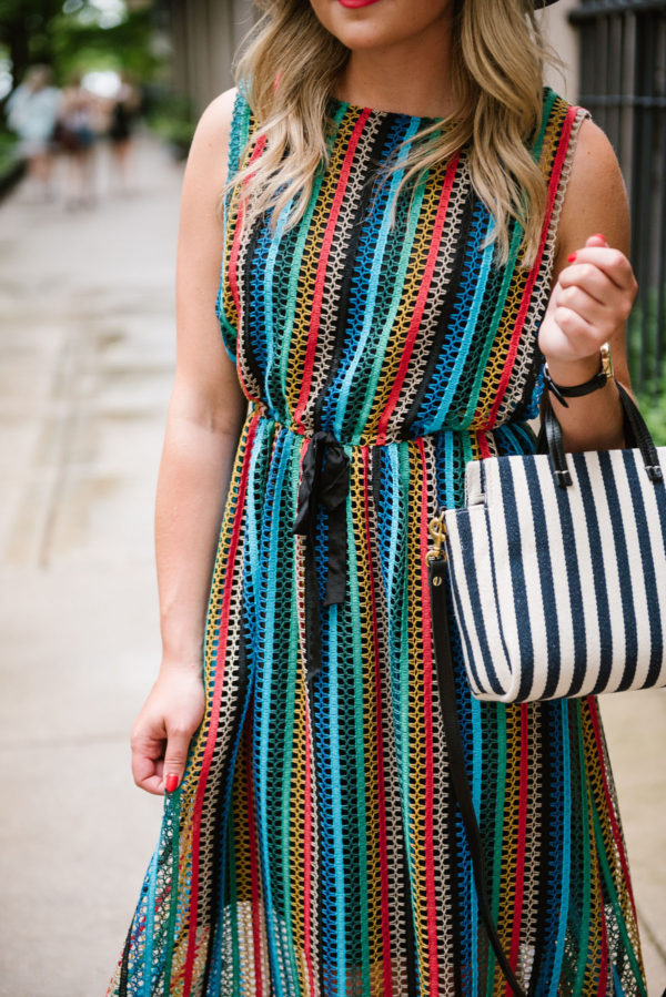 Chicago-based fashion blogger Bows & Sequins wearing an Eva Franco rainbow midi dress with a small striped bag.